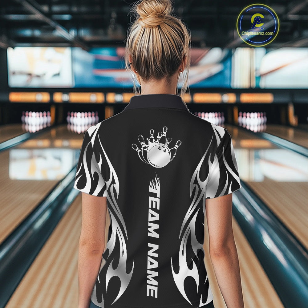 Back view female model inside bowling center wearing black quarter zip shirt featuring silver tribal flame bowling ball and pins artwork