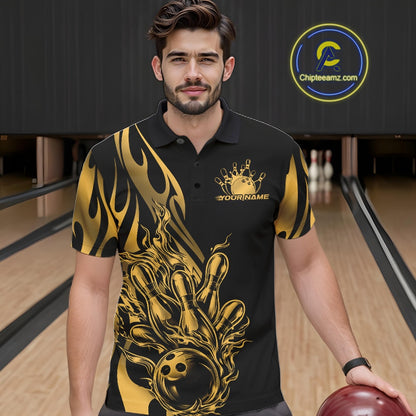 Male model seen from the front in a bowling lane wearing a black polo shirt featuring a golden metal tribal flame bowling ball striking pins in a dynamic action scene.