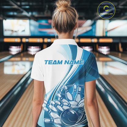 Back view of a female model in a bowling lane wearing a white and blue polo shirt, showcasing dynamic bowling ball crashing into pins artwork.