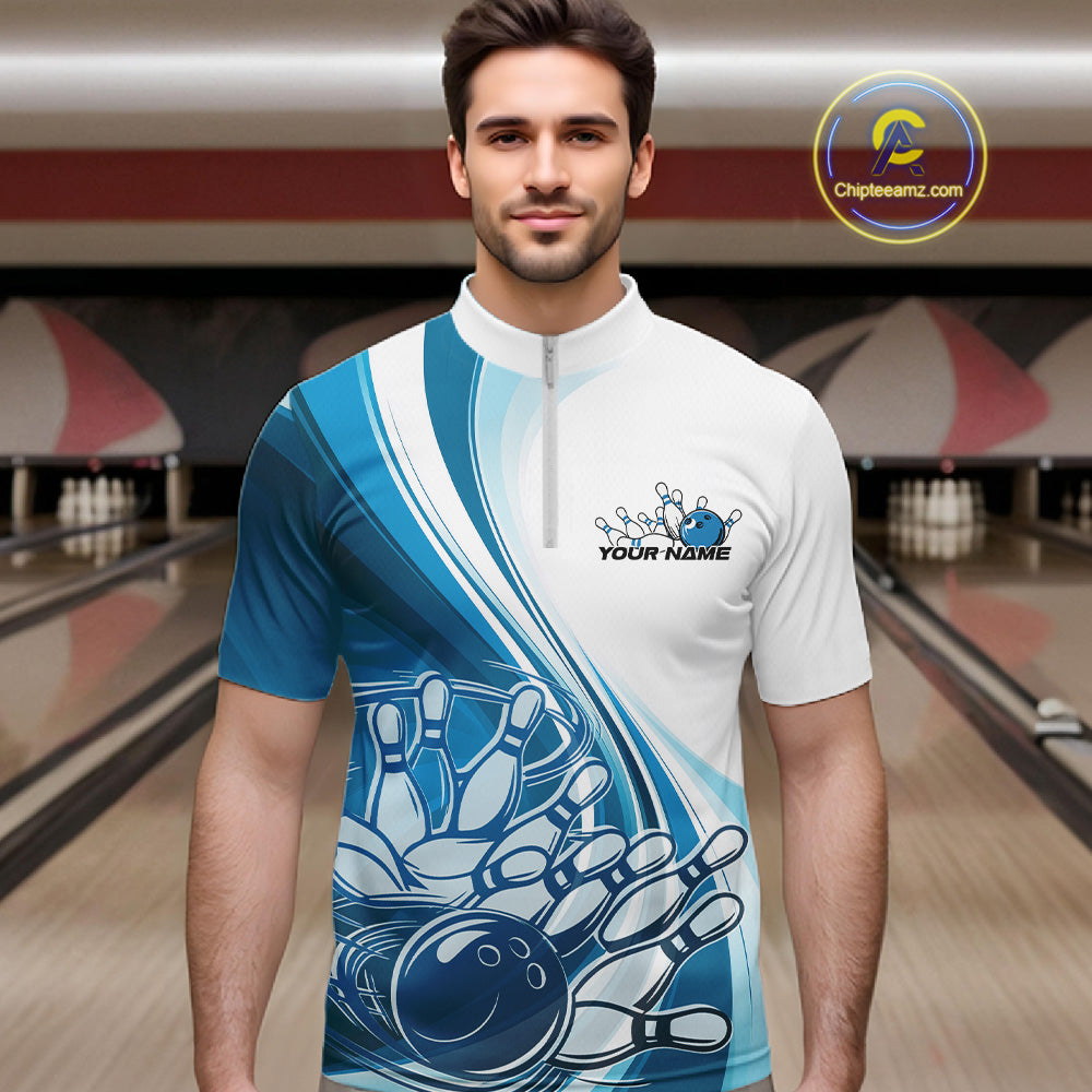 Male model in a bowling alley wearing a white and blue quarter zip shirt, showing a sweeping curve bowling ball striking pins design.