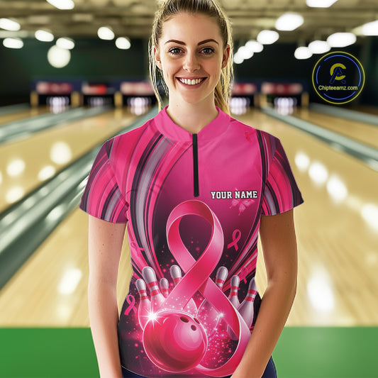 Front view of a female model wearing a pink and black bowling quarter zip featuring breast cancer awareness ribbons and bowling graphics