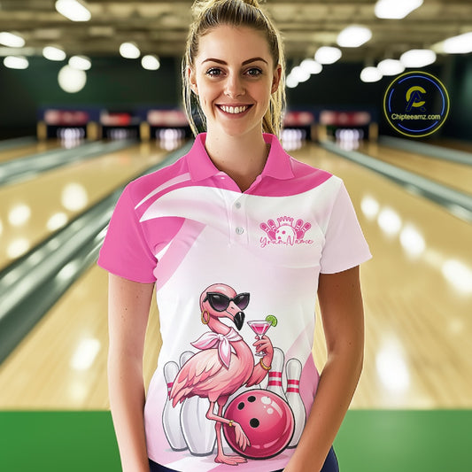 Female model wearing a pink bowling polo shirt at a bowling lane with a stylish flamingo, cocktail, and bowling ball motif.