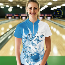 Load image into Gallery viewer, Female model wearing a white and blue bowling quarter zip with butterfly artwork and bowling graphics, front view inside a bowling alley