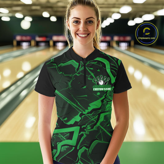 Female model wearing a black and green bowling quarter-zip in a bowling lane featuring sharp geometric lines and cracked pattern artwork.