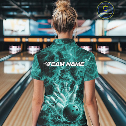Back view of a womens bowling polo displaying a turquoise blue bowling ball striking pins against flames.