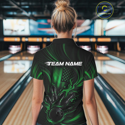 Back view of a female model in a bowling alley wearing a black and green bowling polo featuring flaming bowling action and American flag accents.
