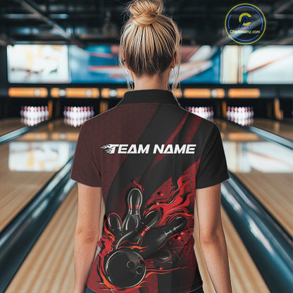 Back view of a female model in a bowling center wearing a black and red polo shirt featuring a flaming bowling ball and pin design.
