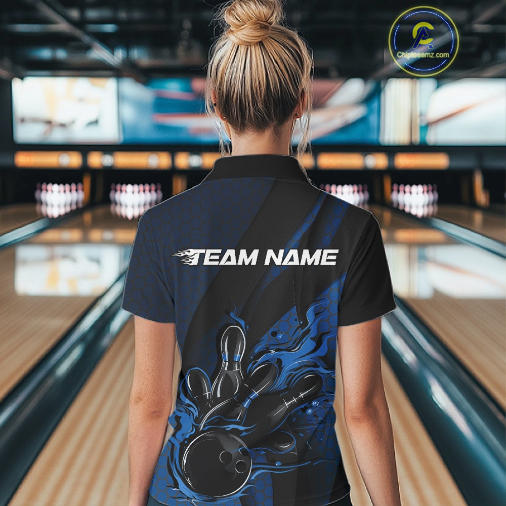 Back view of a female model in a bowling venue wearing a black and blue polo shirt featuring a bowling strike motif with flame effects.