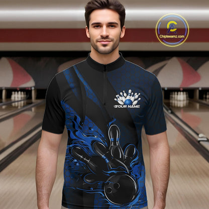 Male model at a bowling lane wearing a black and blue bowling quarter-zip shirt with fiery bowling strike artwork, hexagonal details, and diagonal striping.