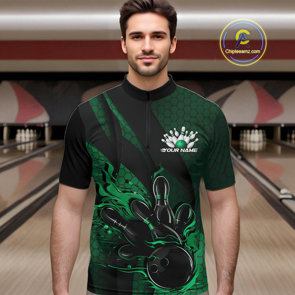 Male model wearing a black and green bowling quarter-zip shirt at a bowling lane with fiery bowling action artwork, hexagon motifs, and diagonal stripes.