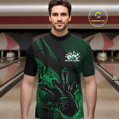 Male model wearing a black and green bowling quarter-zip shirt at a bowling lane with fiery bowling action artwork, hexagon motifs, and diagonal stripes.