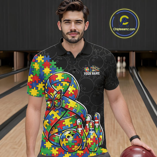 Male model in a bowling lane wearing a black polo shirt, front view featuring autism ribbon puzzle design, butterfly, and bowling strike artwork