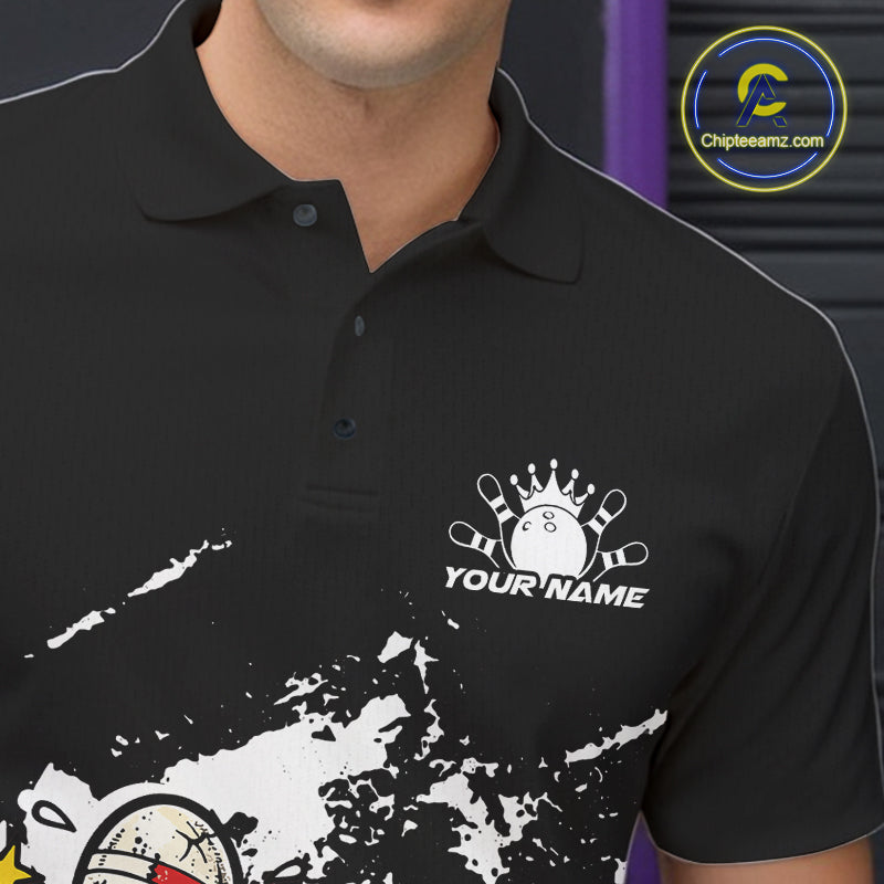 Close-up view of left chest area of a black and white polo shirt, showing small boxing bowling ball and pin graphic detail.