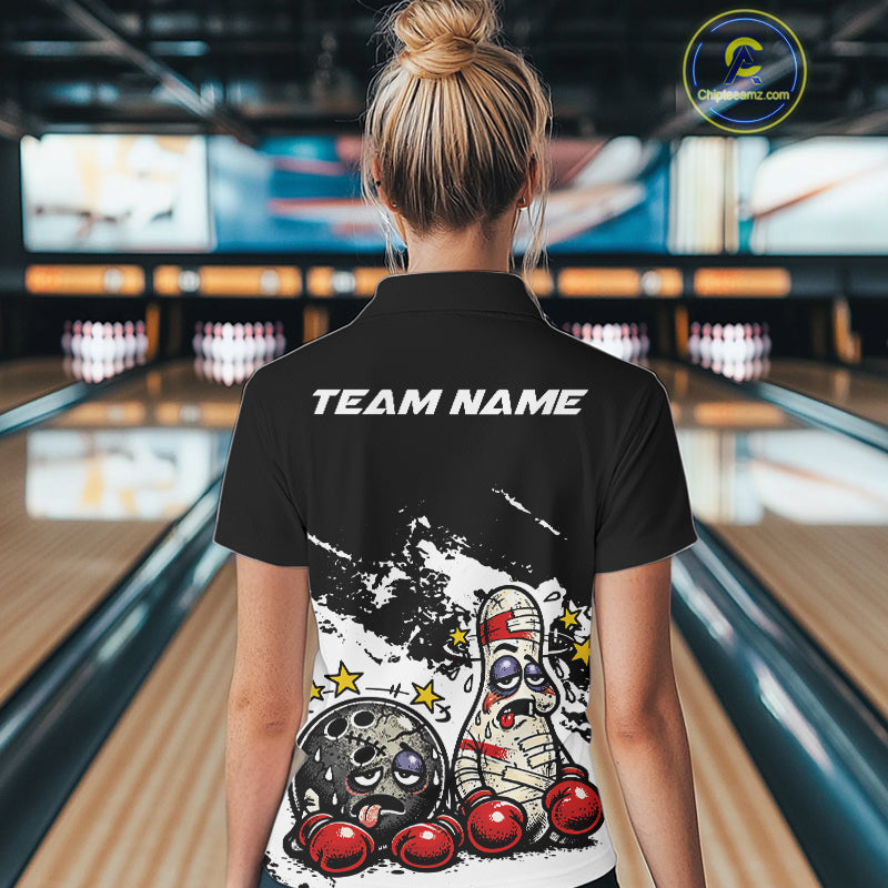 Back view of a female bowler in a black and white quarter-zip shirt, playful boxing bowling ball and pin artwork across the back panel.
