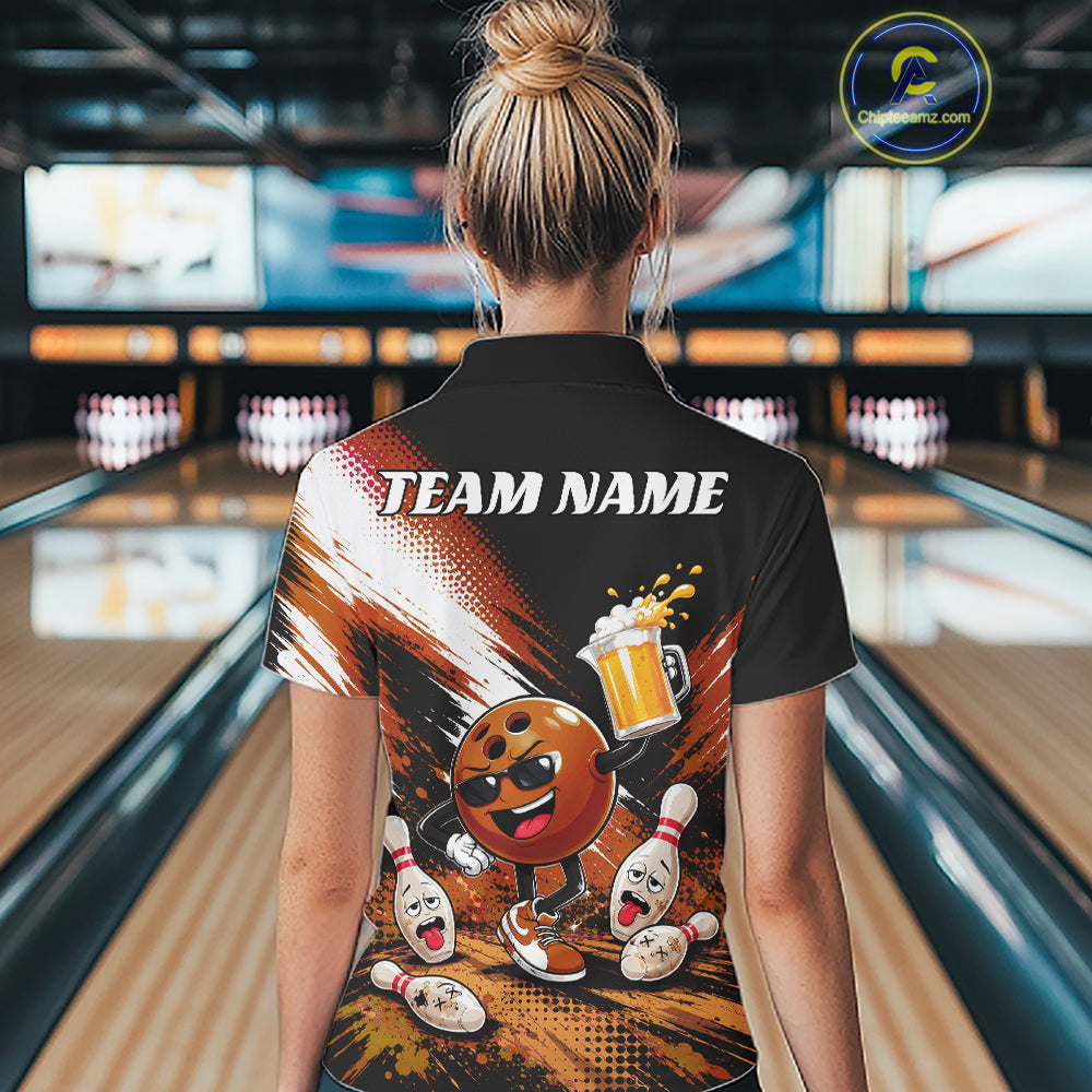 A woman viewed from behind wearing a black short-sleeve bowling-themed quarter zip shirt with a large colorful back graphic featuring a cartoon bowling ball, pins, and the text 'TEAM NAME'. The background shows a blurred bowling alley interior.