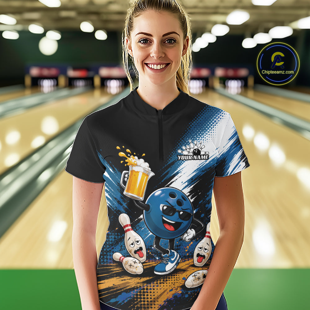 A woman stands in a bowling alley wearing a custom short-sleeve bowling quarter zip shirt. The shirt features a black collar and upper chest, transitioning into a blue and white graphic design with a cartoon bowling ball character, bowling pins, and a beer mug.