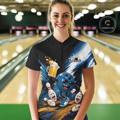 A woman stands in a bowling alley wearing a custom short-sleeve bowling quarter zip shirt. The shirt features a black collar and upper chest, transitioning into a blue and white graphic design with a cartoon bowling ball character, bowling pins, and a beer mug.