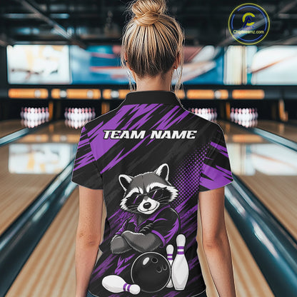 A woman viewed from behind wearing a custom bowling-themed short-sleeve collared shirt with a raccoon graphic and 'TEAM NAME' text on the back, standing in a bowling alley.