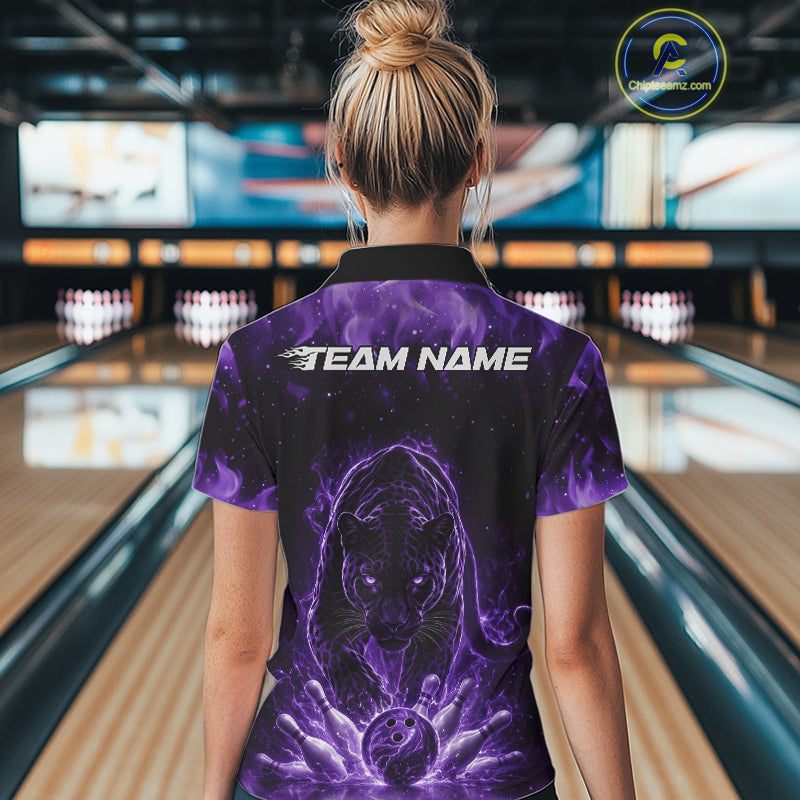 Back view of a female model in a bowling lane wearing a black polo shirt featuring glowing purple electric panther design with bowling ball crashing through pins visuals.