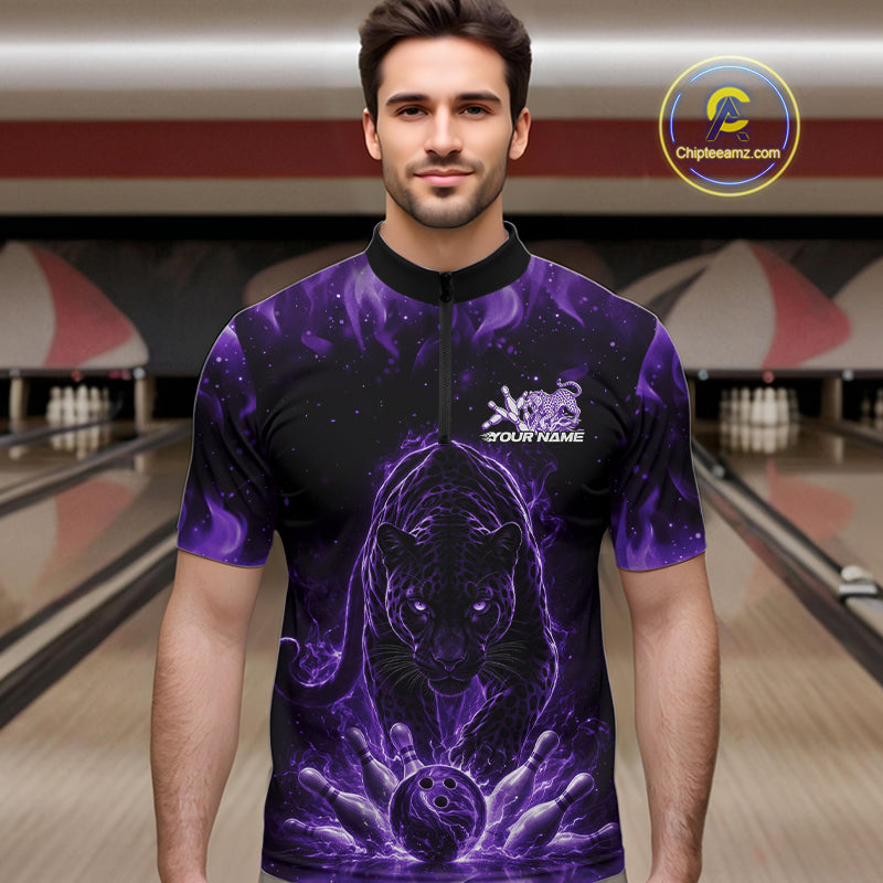 Front view of a male model in a bowling lane wearing a black quarter-zip shirt with glowing purple electric panther and bowling ball striking pins illustration.