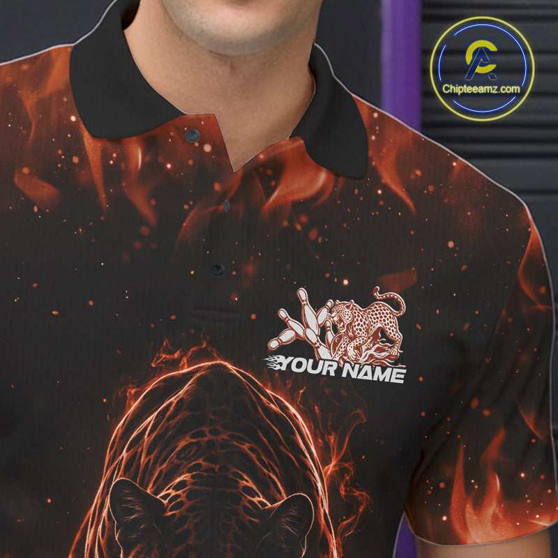 Close-up view of the left chest area of a black bowling polo shirt showing glowing orange electric panther with bowling ball crashing through pins detail.