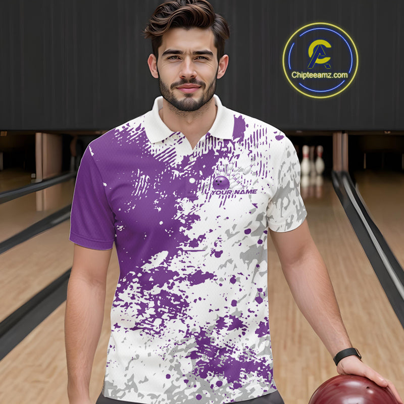 Front view of a male model in a bowling lane wearing a purple and white splatter polo shirt with clean sporty bowling graphics.
