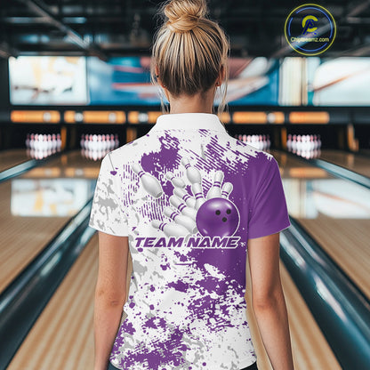 Back view female model in bowling lane wearing white polo with purple and white splatter background, relaxed pose in bowling venue
