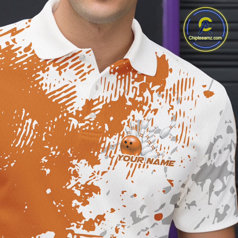 Close-up view of the left chest of an orange and white splatter bowling polo shirt featuring minimal abstract bowling design detail.