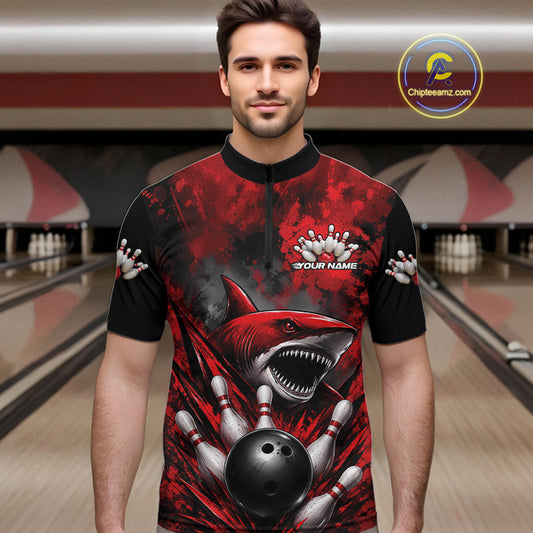 Man wearing a red and black bowling shirt with a shark design in a bowling alley.