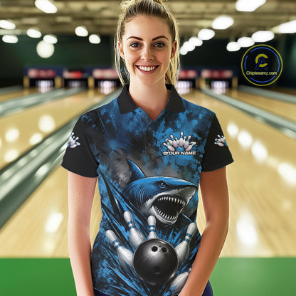 Woman wearing a blue and black bowling shirt with a shark design in a bowling alley.