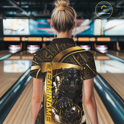A woman viewed from behind in a bowling alley, wearing a black short-sleeve collared shirt with a large gold and black graphic print featuring a panther and the text 'TEAM NAME' and 'CZECHOWSKI'.