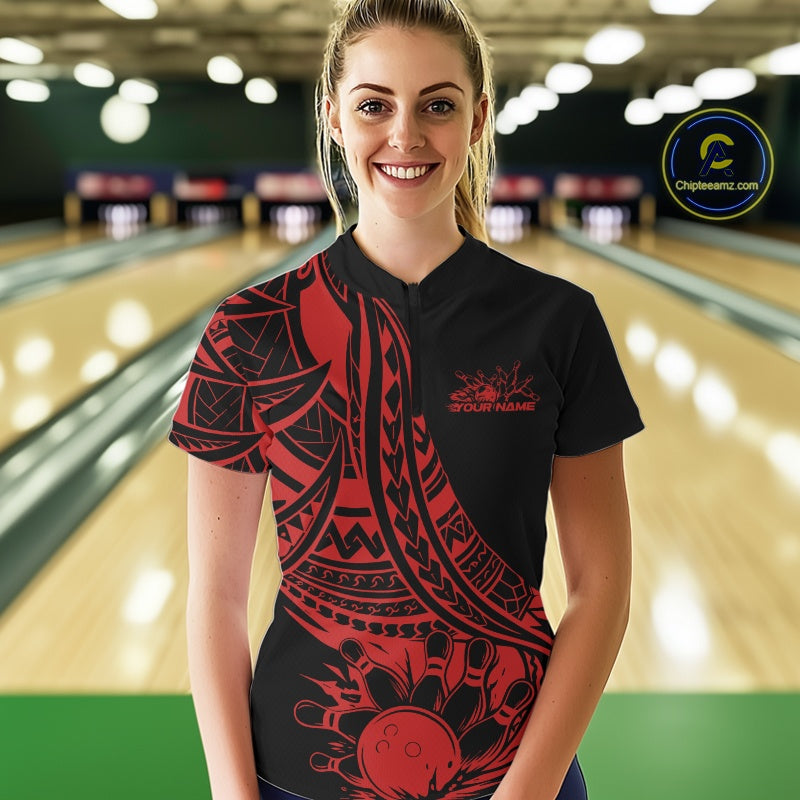 Woman wearing a black and red bowling shirt with a logo in a bowling alley.