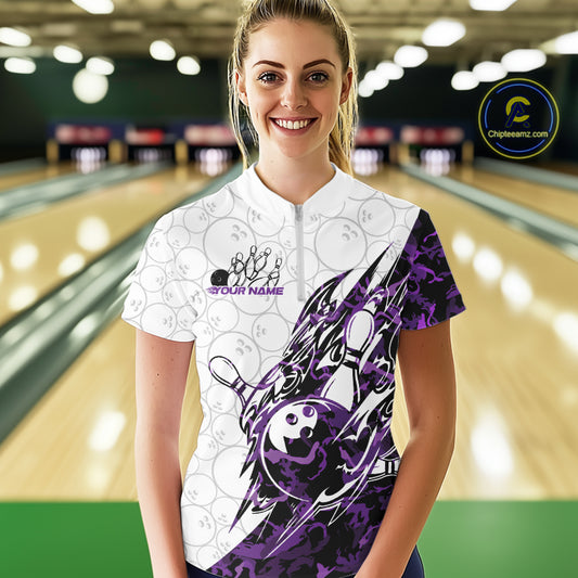 Female model wearing a white bowling quarter-zip shirt at the bowling lane with purple camo bowling graphics and faint ball patterns.