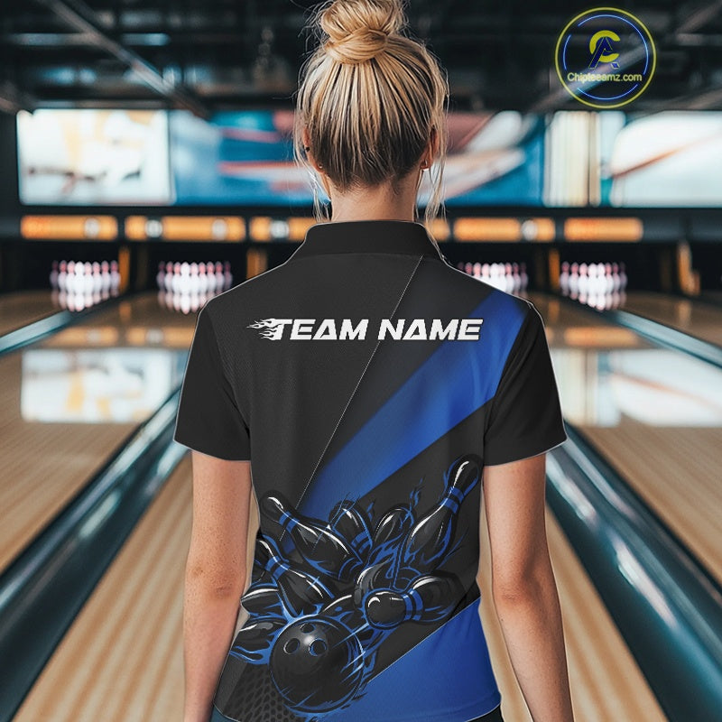 Back view female model at bowling lane wearing black and blue quarter zip shirt featuring flaming bowling ball striking pins illustration