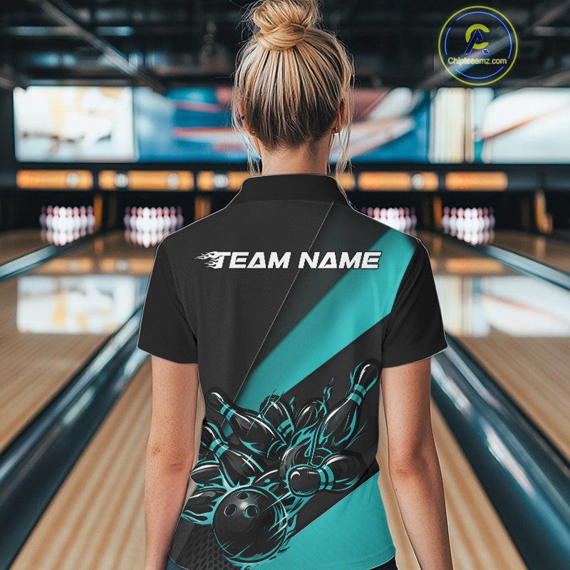Back view female model in bowling alley wearing black and turquoise blue quarter zip shirt featuring flaming bowling action graphics