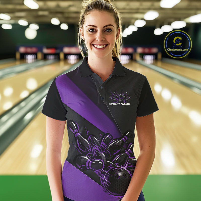 Female model front view in bowling lane wearing black and purple polo shirt with flaming bowling ball hitting pins in energetic sports action design.