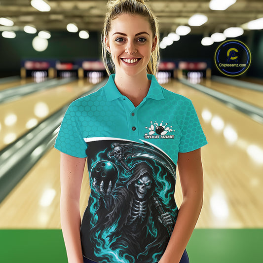 A woman stands in a bowling alley wearing a custom short-sleeve polo shirt. The shirt features a bright turquoise blue top with a large graphic print on the front showing a grim reaper skeleton holding a bowling ball with teal flames