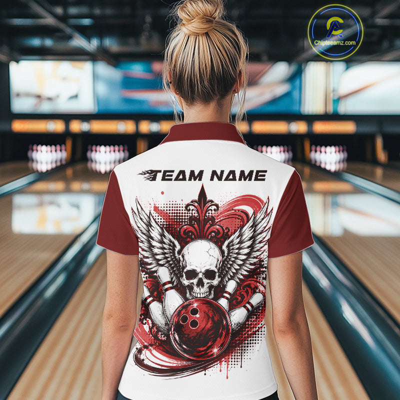 Back view of a woman in a bowling alley wearing a bowling shirt with polo collar, red skull-themed bowling graphic with black wings, pins, bowling ball shirt with “Team Name” across the shoulders.