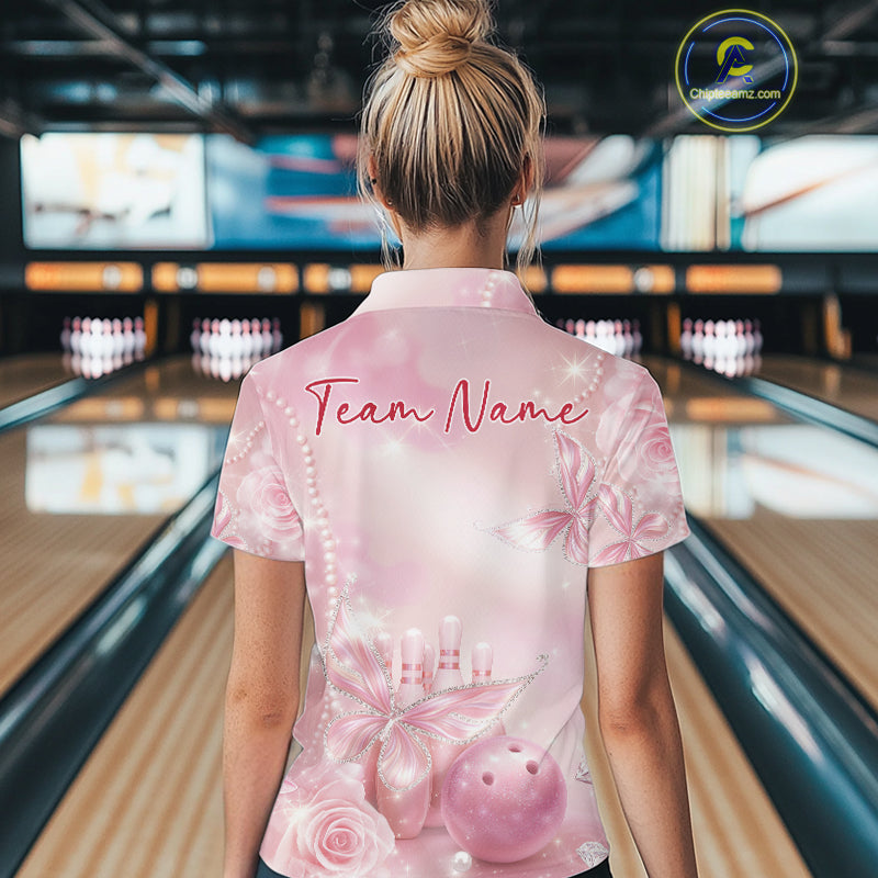 Back view of a female model at a bowling lane wearing a polo shirt featuring glitter butterfly motifs, diamonds, bowling pins, and a bowling ball.