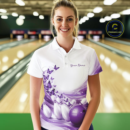 Front view of a female model wearing a white and purple bowling polo shirt featuring butterfly accents and bowling graphics at the bowling lane.