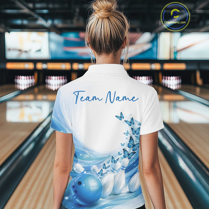 Back view of a women s white and blue bowling polo shirt showcasing butterfly accents and bowling graphics in a bowling venue.