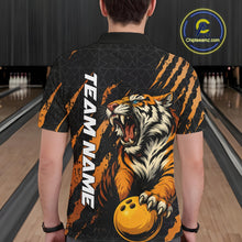 Load image into Gallery viewer, Back view of a male model wearing a black and yellow bowling polo shirt at a bowling lane, featuring a roaring tiger holding a yellow bowling ball with orange claw-stripe artwork and a geometric background pattern.