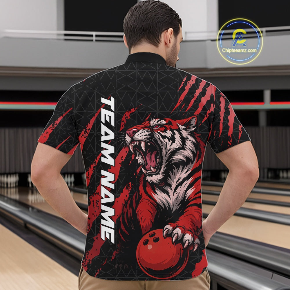 Male model wearing a black and red bowling quarter-zip shirt at a bowling lane featuring a roaring tiger holding a red bowling ball with matching claw-stripe artwork and a geometric background pattern.