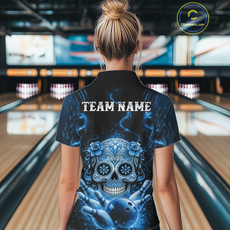 Back view of a female model in a bowling venue wearing a black and blue bowling polo featuring Day of the Dead sugar skull design.