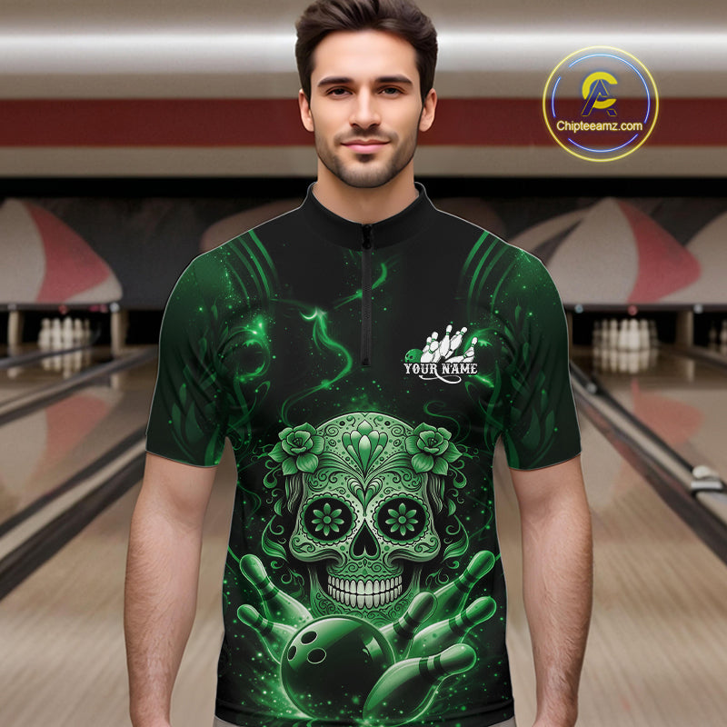 Male model wearing a black and green bowling quarter-zip shirt at a bowling lane with Day of the Dead sugar skull artwork and bowling-themed graphics.