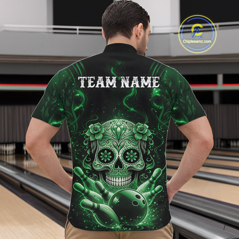 Front view of a male model in a bowling venue wearing a black and green quarter-zip shirt featuring a floral sugar skull above bowling pins and a bowling ball.
