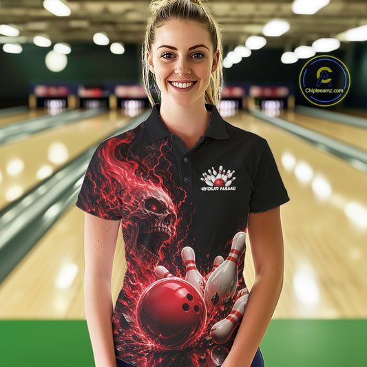Front view of a female model in a bowling alley wearing a black bowling polo with a red flaming skull, lightning, bowling pins, and a custom name.
