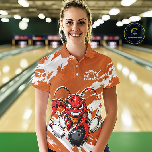Front view of a female model in a bowling alley wearing an orange custom bowling polo shirt with a fierce yet funny crawfish bowling character and a distressed background design.