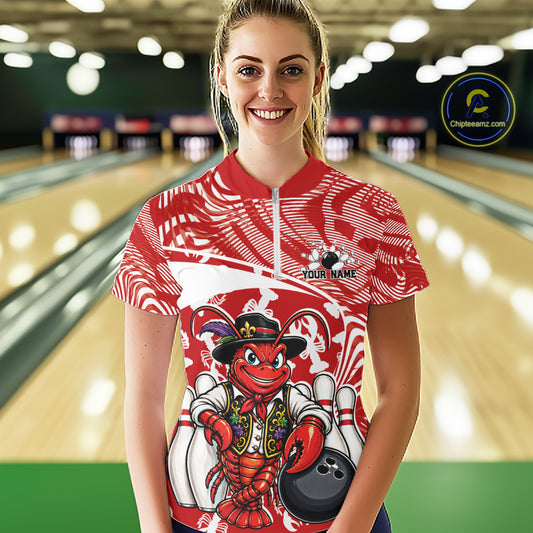 Front view of a happy female model in a bowling alley wearing a red custom quarter-zip bowling shirt with a funny Cajun crawfish leaning on a bowling ball and a swamp-inspired texture background.