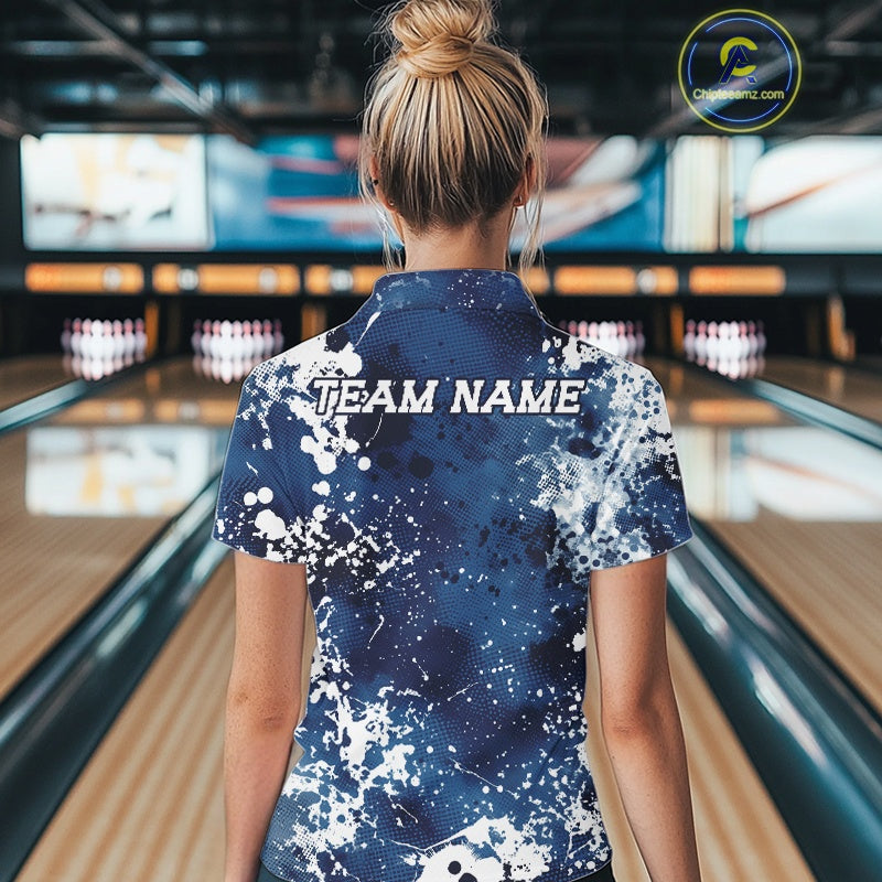 Person wearing a blue and white 'TEAM NAME' shirt in a bowling alley.